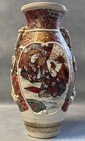 Front view of 12-inch Japanese Satsuma porcelain vase showing detailed raised relief figures and ornate patterns.