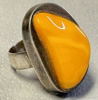 Close-up photo of the ring showing the large amber stone set in silver.