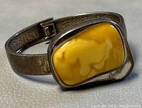 Close-up of amber stone and silver bracelet showing color and texture details