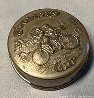 Top view of collapsible cup showing embossed design of two people riding a bicycle with text Travelers Cups.