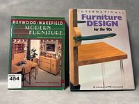 Photo showing both books side by side: 'Heywood-Wakefield Modern Furniture' and 'International Furniture Design for the 90s' on a gray background.