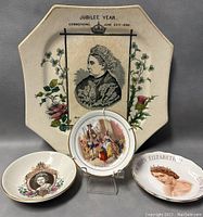 Front view of all three plates: one large octagonal Queen Victoria plate and two smaller round Queen Elizabeth mini plates displayed on stands.