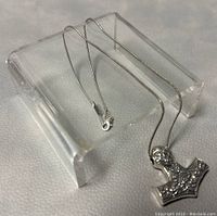 Pendant and chain displayed on a clear stand showing full length and clasp end.