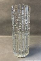 Clear textured glass vase front view showing cylindrical shape with vertical block-like texture.