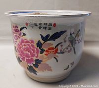 Side view of the planter showing detailed hand-painted flowers and birds with Chinese characters on white porcelain.