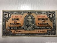 Front view of 1937 $50 Bank of Canada banknote with portrait of King George VI and red serial number BA4945368.