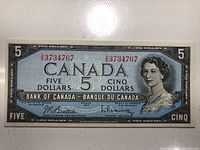Front view of the 1954 Canadian five dollar banknote showing Queen Elizabeth II portrait and serial number V/37 34767