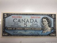 Front view of 1954 Canadian $5 banknote with Queen Elizabeth II portrait and serial number.
