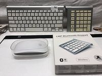 Photo showing Apple wireless keyboard, Apple Magic Mouse in clear case, LMP Bluetooth numeric keypad in box and Apple keypad side by side