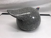 Side view of a ceramic guinea fowl statue showing body shape and polka dot pattern