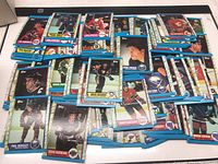 Multiple 1989 Topps hockey cards scattered on a flat surface showing various NHL player portraits and action shots.