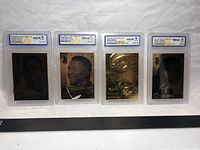 Wide view showing the four graded 2003 Merrick Mint Laser 23 Karat Gold baseball cards featuring Albert Pujols, Pedro Martinez, Todd Helton, and Randy Johnson, each encased in plastic protective holders.