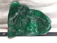 Close-up of polished malachite showing green banding patterns and smooth glossy surface