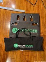 Black Body Boss Total Workout System base platform with numbered slots 1-5 for fitness attachments, placed on the floor.