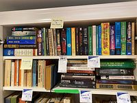 Two shelves of books containing mysteries, thrillers, classics, and fiction. Books neatly arranged with some category labels visible.