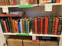 Bookshelves containing classic literature books with ornate hardcovers and gilt details.