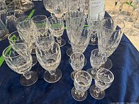 Group of glasses on navy cloth showing collection of short stem crystal glasses