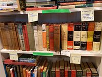 Shelf with multiple Churchill books including first edition series 'The Second World War' and signed 'White Cockade'. Books show wear, some with attached price tags or markings.