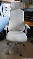 Front view of the white mesh back office chair with headrest and cushioned seat.