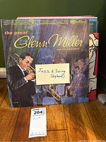 Front cover of The Great Glenn Miller and His Orchestra vinyl record showing a blue artistic illustration of Glenn Miller playing trombone with a handwritten note "Jazz & Swing (big band)".