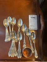 Top-down view of all spoons and napkin ring arranged on table.