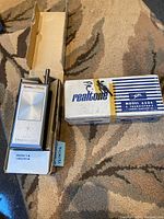 Two vintage Realtone Model 6504 handheld walkie-talkies in original packaging, one box open showing device, the other closed.