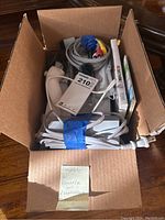 Open box showing Nintendo Wii console with two controllers, cables, and 2 game cases inside.