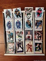 Top view of several hockey cards visible in the storage box showing cards from different teams and card designs.