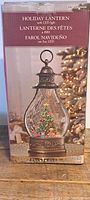 Boxed holiday lantern featuring a Christmas tree scene inside glass with LED and water blower