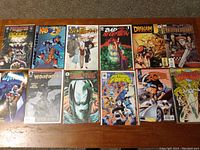 Top-down photo showing all 12 comic books laid out on a table, displaying covers from various publishers and years.