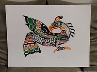 Full view of the Thunderbird print showing the stylized Indigenous art design with colors black, green, orange, and red.