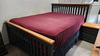 Queen size wood bed frame painted black with natural pine top rails, slatted headboard and footboard