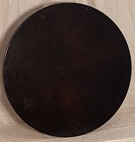 Top view of round wooden Lazy Susan showing smooth dark wood surface with wood grain.