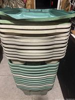 Stacked view of green plastic storage totes showing overall shape, color, and condition.