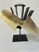 Front view of an eco fan showing brass blades and heat dissipation fins on stand
