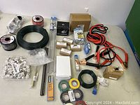 Overview of lot showing rolls of wire, cable clips, tubes, boxes of components, jumper cables, tape rolls, and connectors.