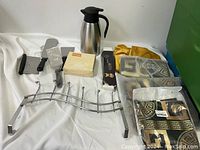 Lot displayed with all items showing kitchen utensils, thermal carafe, pillowcases, and rack