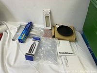 Full overview of lot: including Crate & Barrel photo frames, SodaStream CO2 cylinder, aluminum foil, plastic bags, black round item and other kitchen accessories.