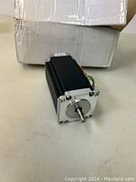 Front and side angled view of the black and silver StepperOnline Nema 23 stepper motor with shaft visible.