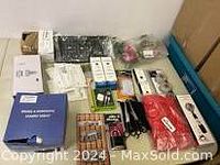 Overview of miscellaneous new household tools, lighting, and hardware items laid out on table.