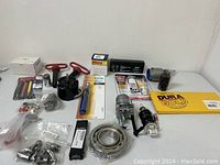 Overview of all automotive and tool items on white table showing packaging and parts