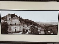 Close-up of the black and white print depicting the church and mountain village, showing detailed architecture and landscape.
