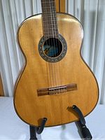 Front view of Maistria acoustic guitar showing wood inlay designs and natural finish