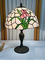 Front view of stained glass orchid table lamp on heavy metal base