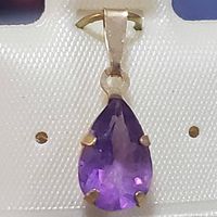 Close-up front view of the pendant showing pear-shaped purple amethyst set in yellow gold with a loop bail.