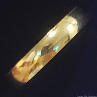 Close-up photo of the yellow gold baby toe ring showing the smooth, polished surface reflecting light.