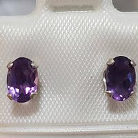 Pair of oval amethyst stud earrings set in sterling silver with four-prong mounts shown front view