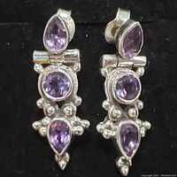 Front view of sterling silver amethyst earrings showing round and teardrop stones with silver bead accents.