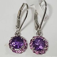 Front view of sterling silver earrings with amethyst center stones and pink stone halos.