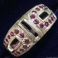 Close-up image of the ring showing the geometric design and multiple small round rubies embedded in sterling silver.